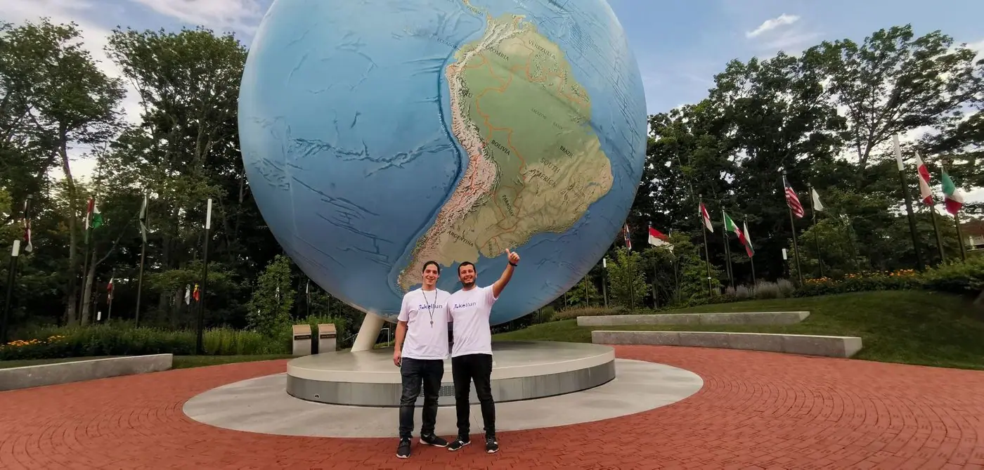 2 personas frente al globo terráqueo del campus de Babson College.