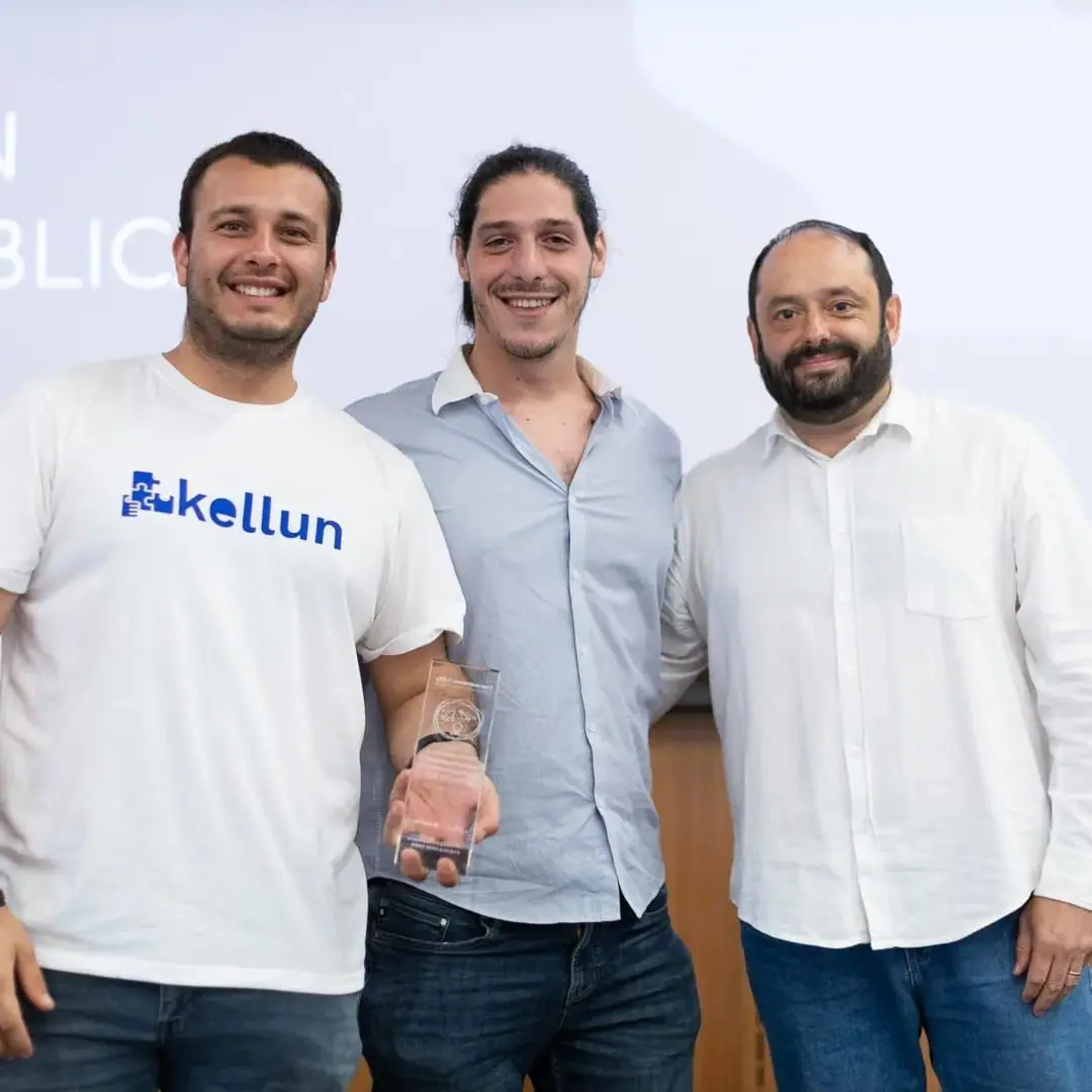 3 personas con camisetas de Kellun sosteniendo el trofeo de la UDD.