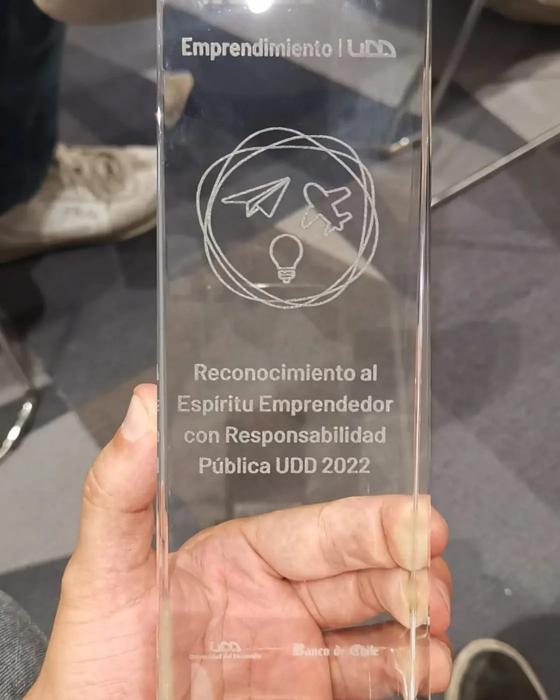 Trofeo de vidrio grabado con el texto Reconocimiento al Espíritu Emprendedor con Responsabilidad Pública UDD 2022.
