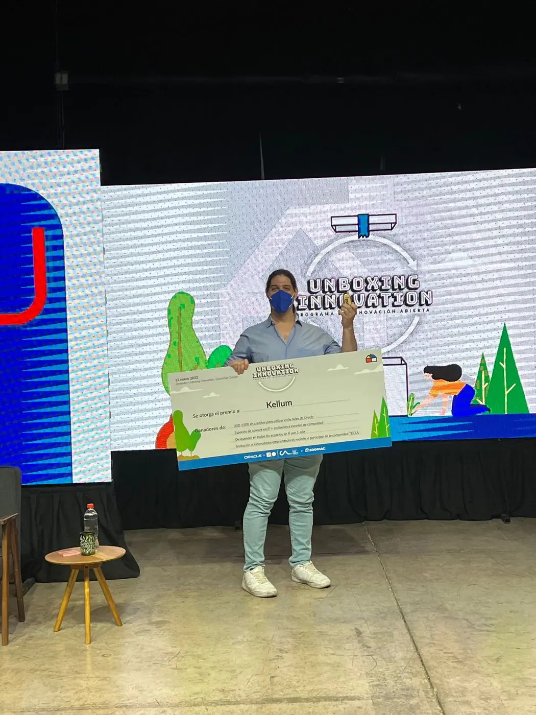 Tomás Ffrench-Davis en el escenario de Unboxing Innovation sosteniendo un cheque de gran formato.